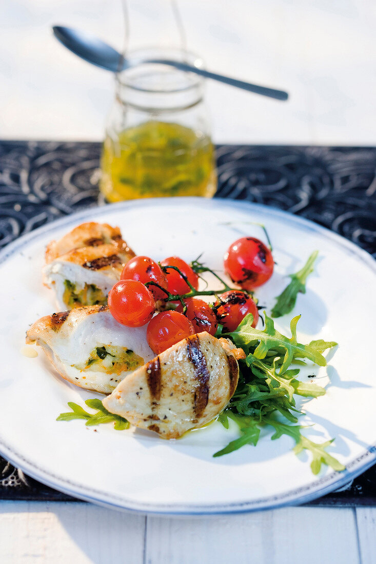 Chicken breast stuffed with cheese, pistachios, orange peel and arugula served on plate