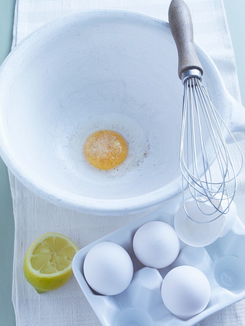 Aufgeschlagenes Ei in Rührschüssel mit Schneebesen