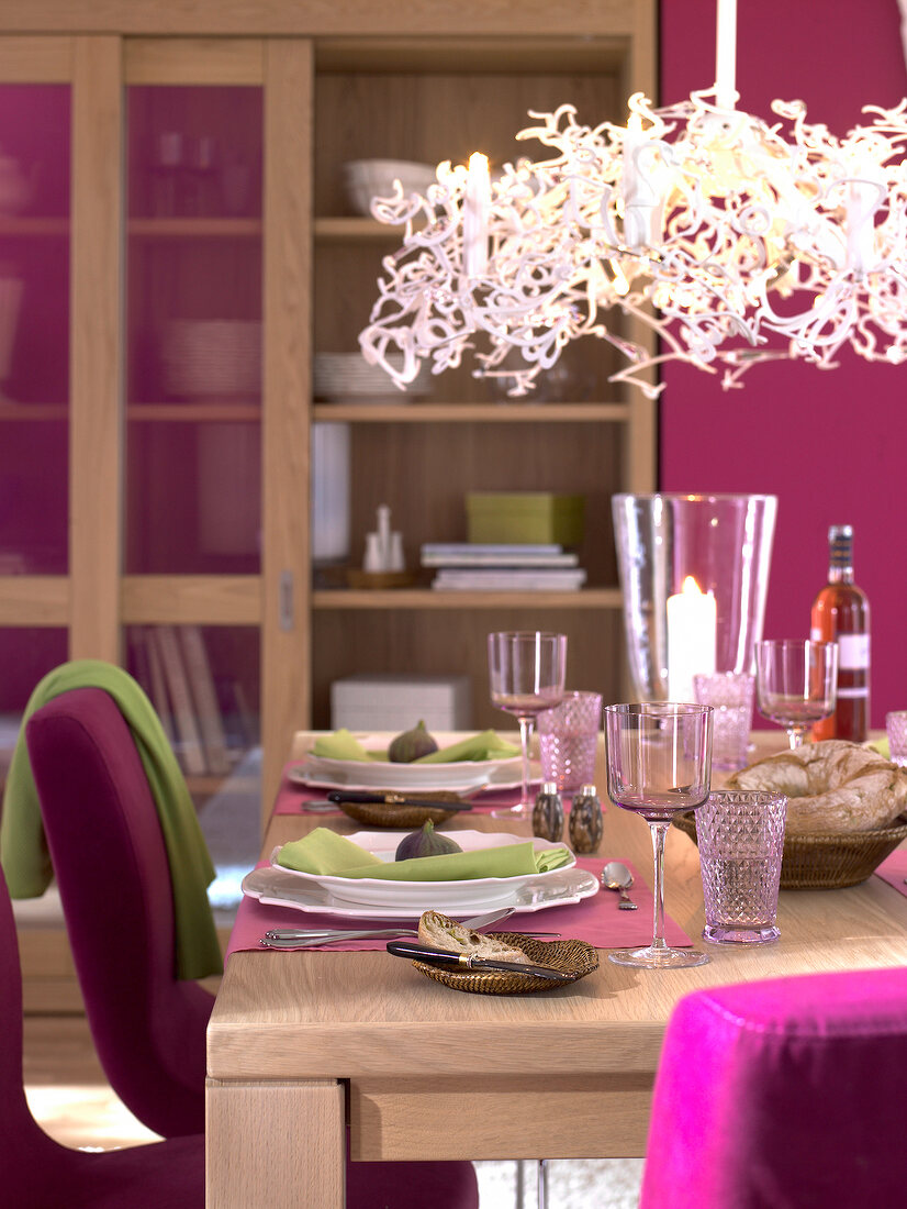 Tisch gedeckt in Pink und Grün, Teller und Leuchte weiß