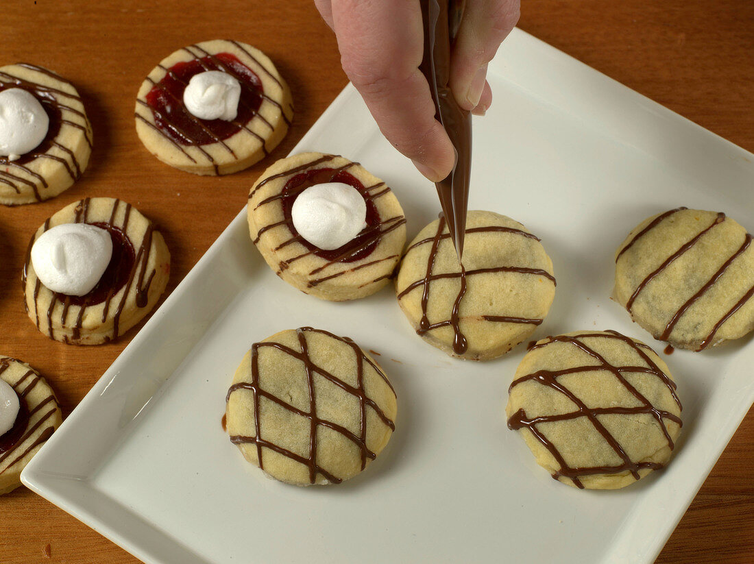 Close-up of chocolate lines being put on cookies
