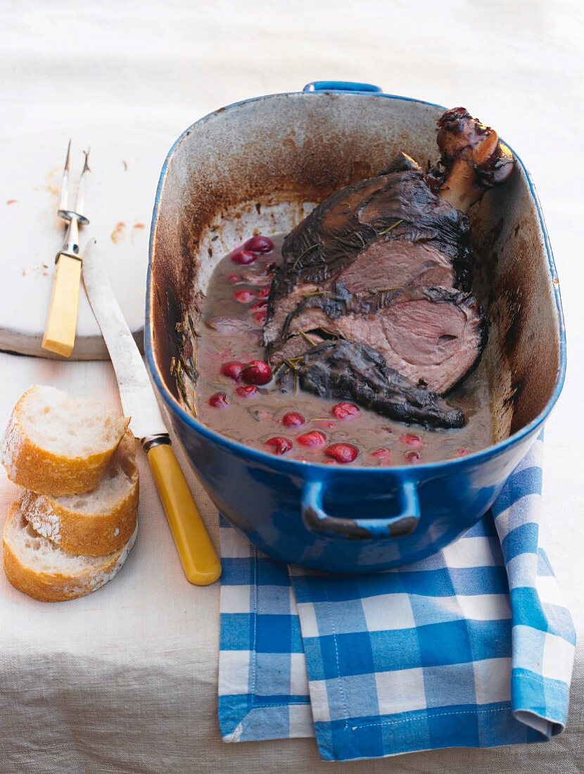 Braised leg of lamb with sour cherries in cooking pot