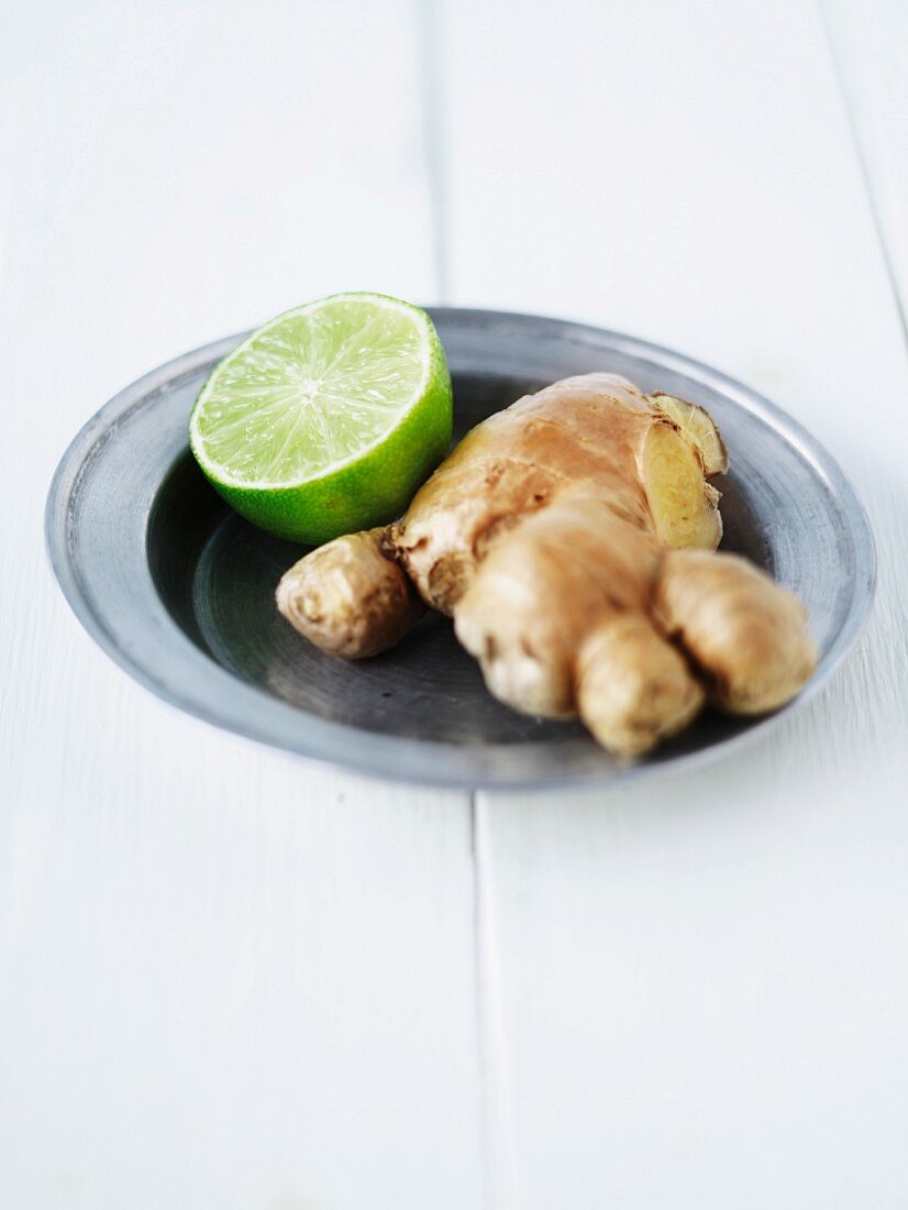 Ginger root and half a lime on a silver plate