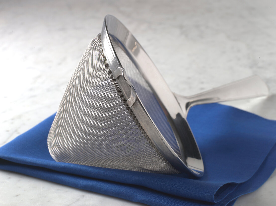 Close-up of sieve on blue folded napkin