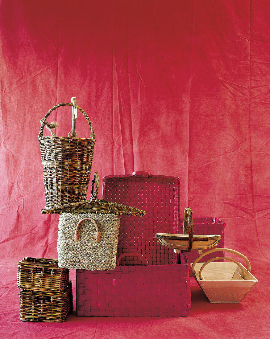 Different types of wicker baskets against red background