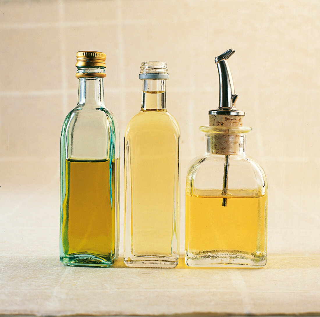 Glass bottles of olive oil, sunflower oil and rapeseed oil