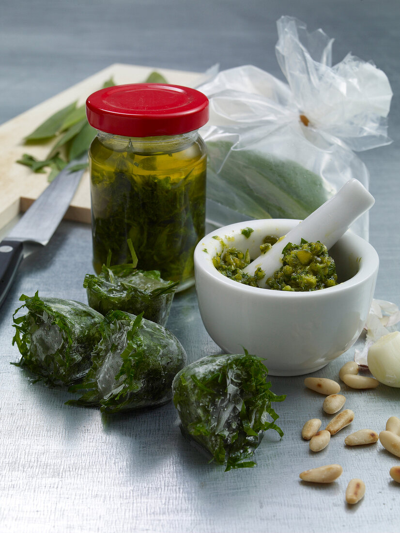 Wild garlic preserved in oil and deep-frozen in glass jar and mortar and pestle