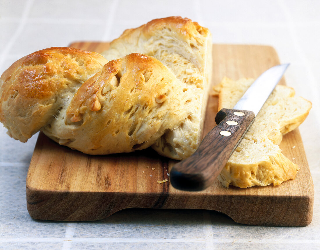 Close-up of sweet braided bread with chopped almonds and bread knife