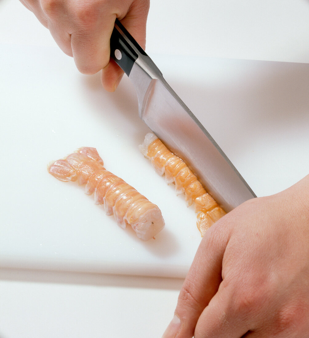 Close-up of shrimp being halved with knife, step 1