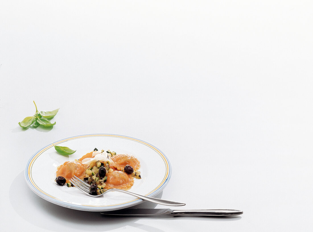 Ravioli pasta with pepper and olives on plate