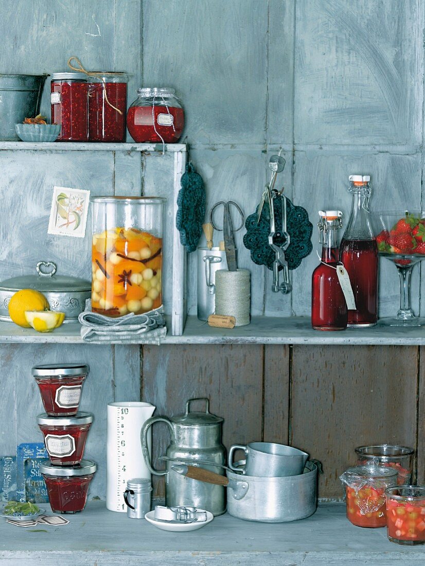Various preserving jars and kitchen utensils on a shelf