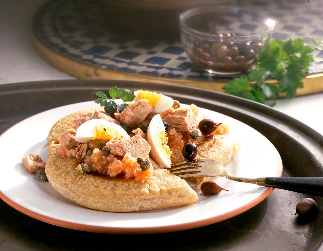 Close-up of sauertiegbrot with lettuce, egg, tuna and olives on plate