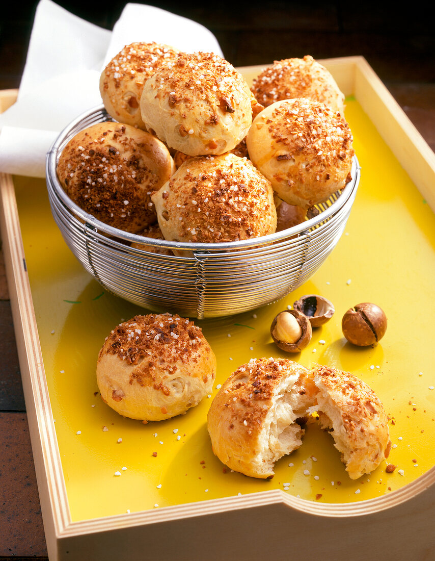Close-up of macadamia bread rolls in basket on yellow tray