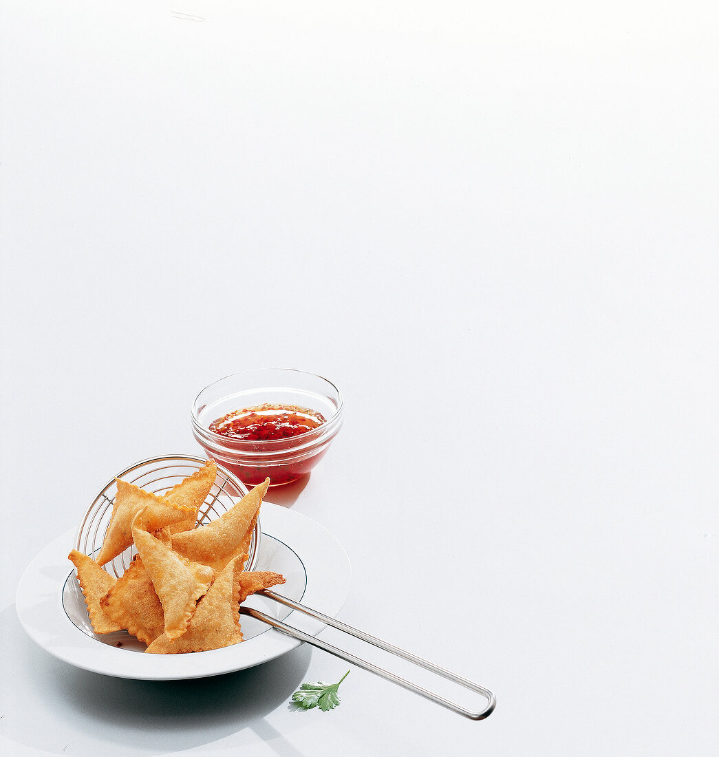 Shrimp triangles with spicy dip on white background