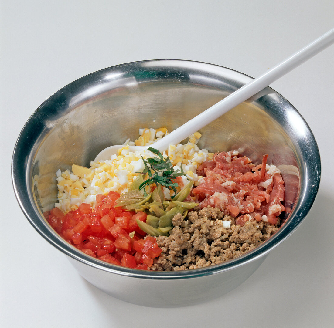 Vegetables and meat in bowl for preparation of stuffed chicken, step 2