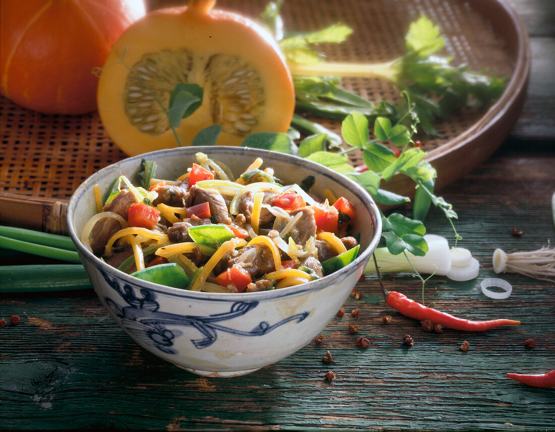 Duck with pumpkin and chilli peppers in bowl