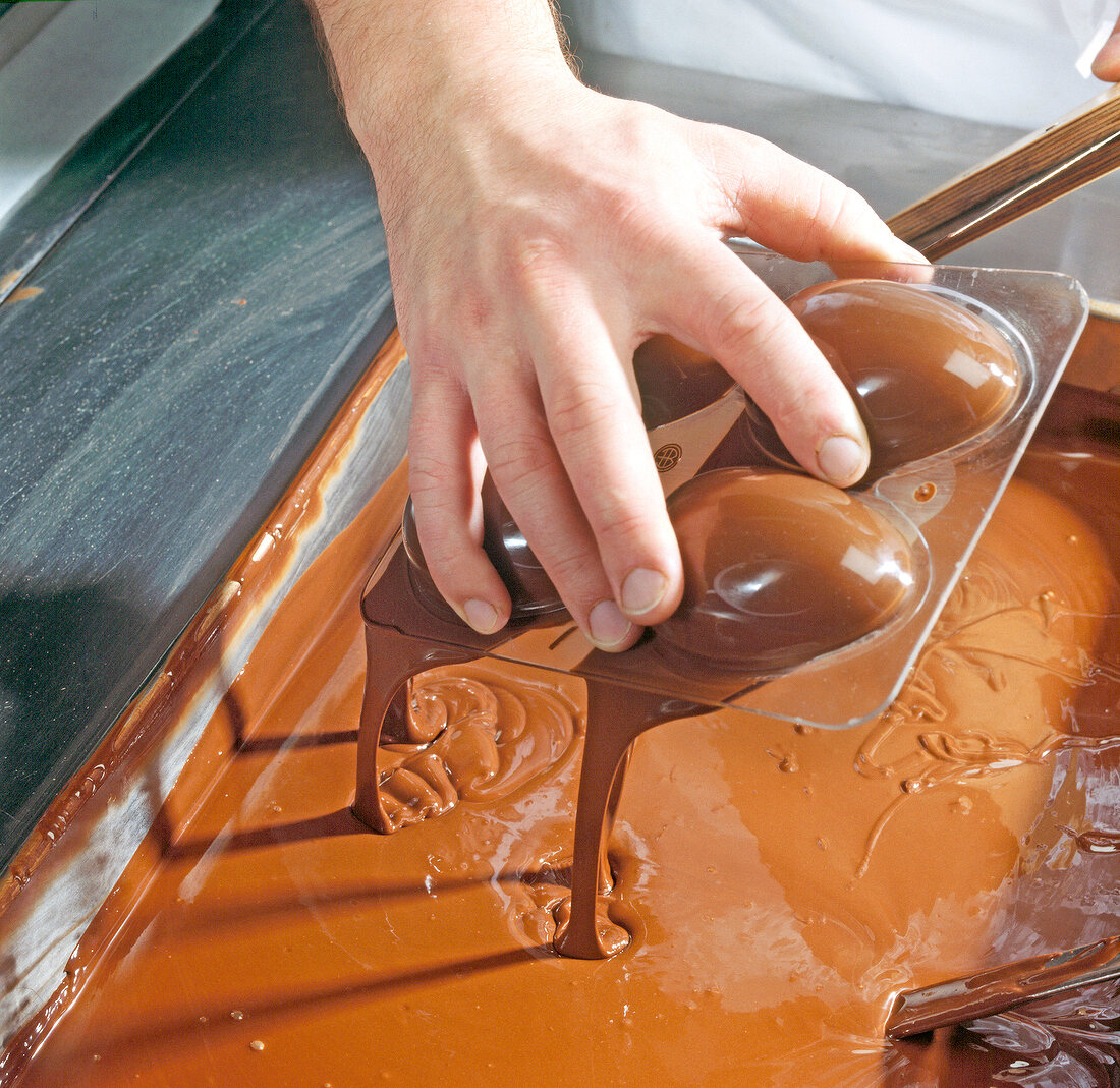 Chocolate being poured out from egg shaped tray, step 2