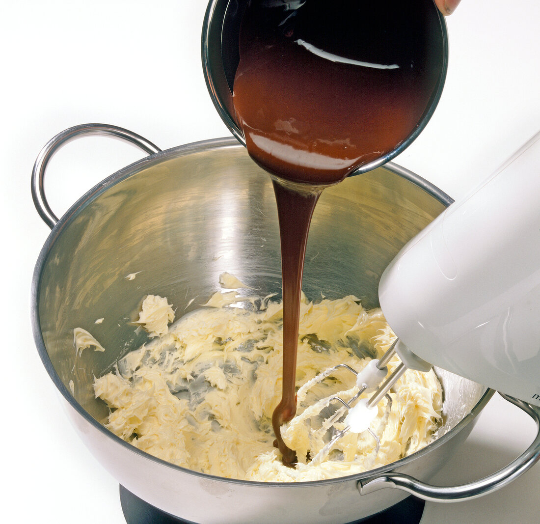 Close-up of liquid chocolate being poured in butter for preparation of chocolate, step 1
