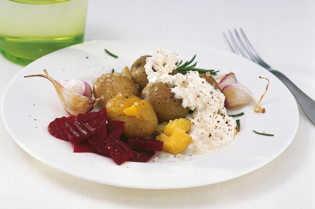 Close-up of baked potato with beetroot and cream cheese in dish