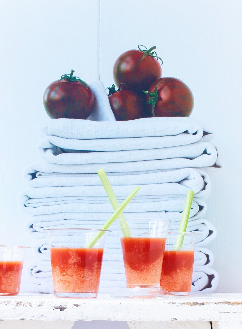Bloody Mary mit Tomatensorbet vor gestapelten Tüchern