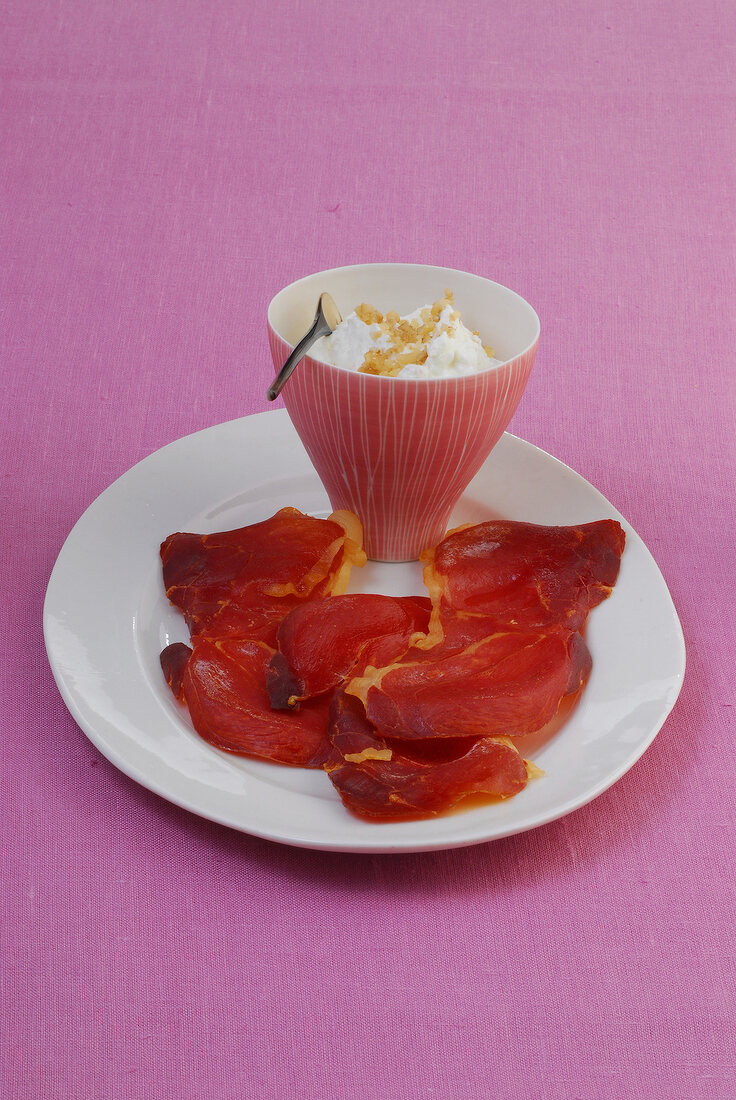Baked crispy serrano ham served with bowl of dip on plate