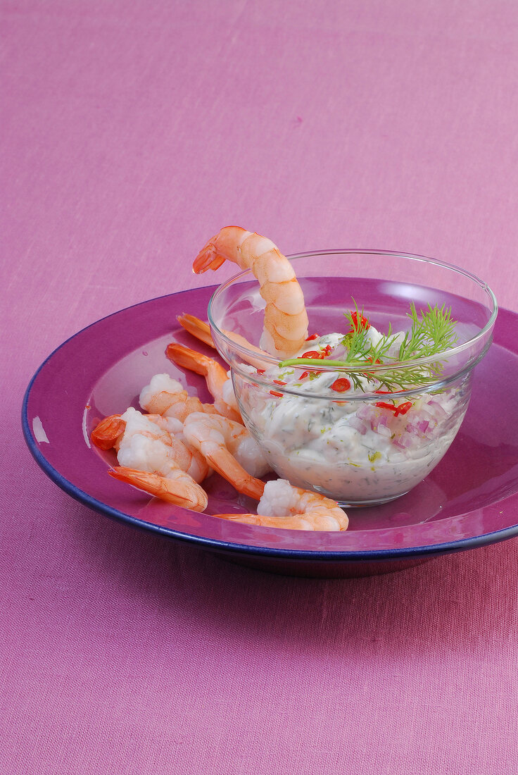 Bowl of dill dip served with shrimps on plate