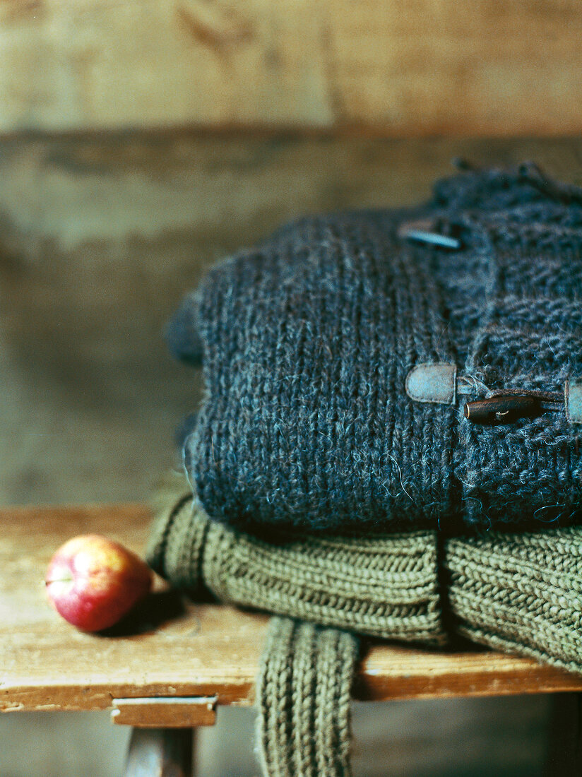 Close-up of green and blue cardigan with horn buttons on wood