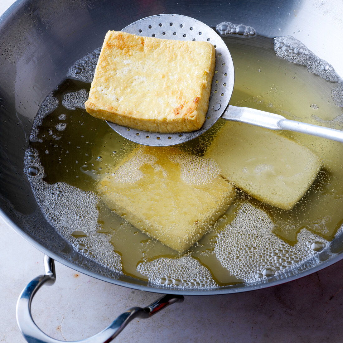 Close-up of tofu being fried in pan, step 2