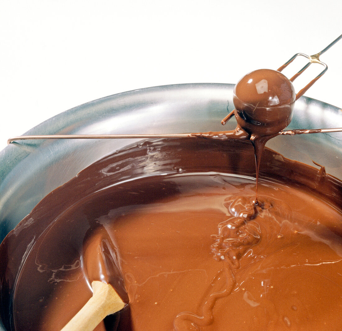 Close-up of chocolate balls being drained of chocolate, step 2