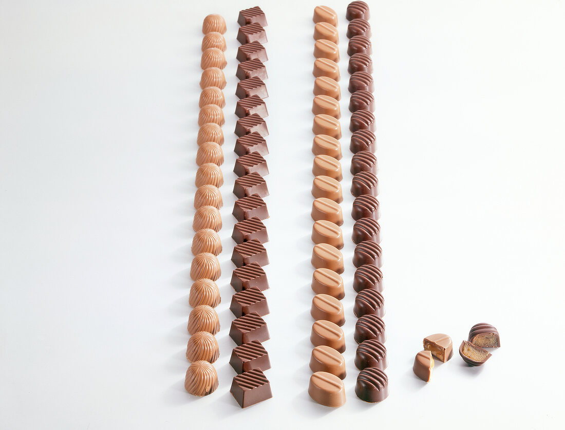 Variety of chocolates in rows on white background
