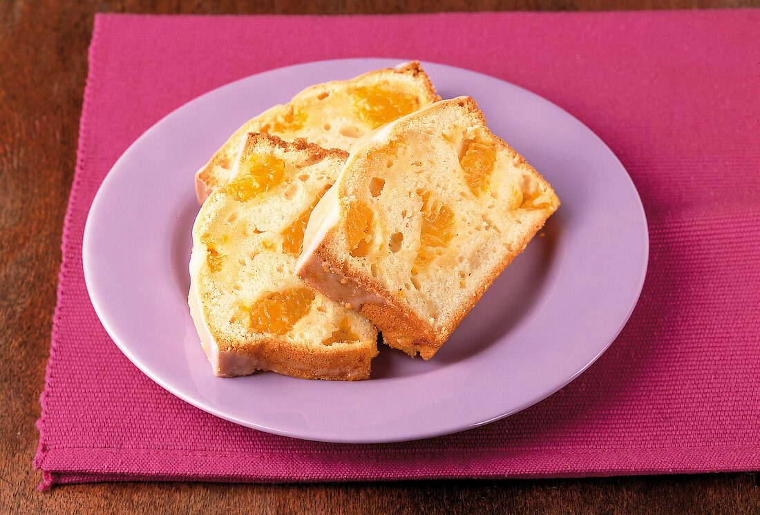 Backen, 3 Stücke Mandarinenkuchen mit Zuckerguss auf lila Teller