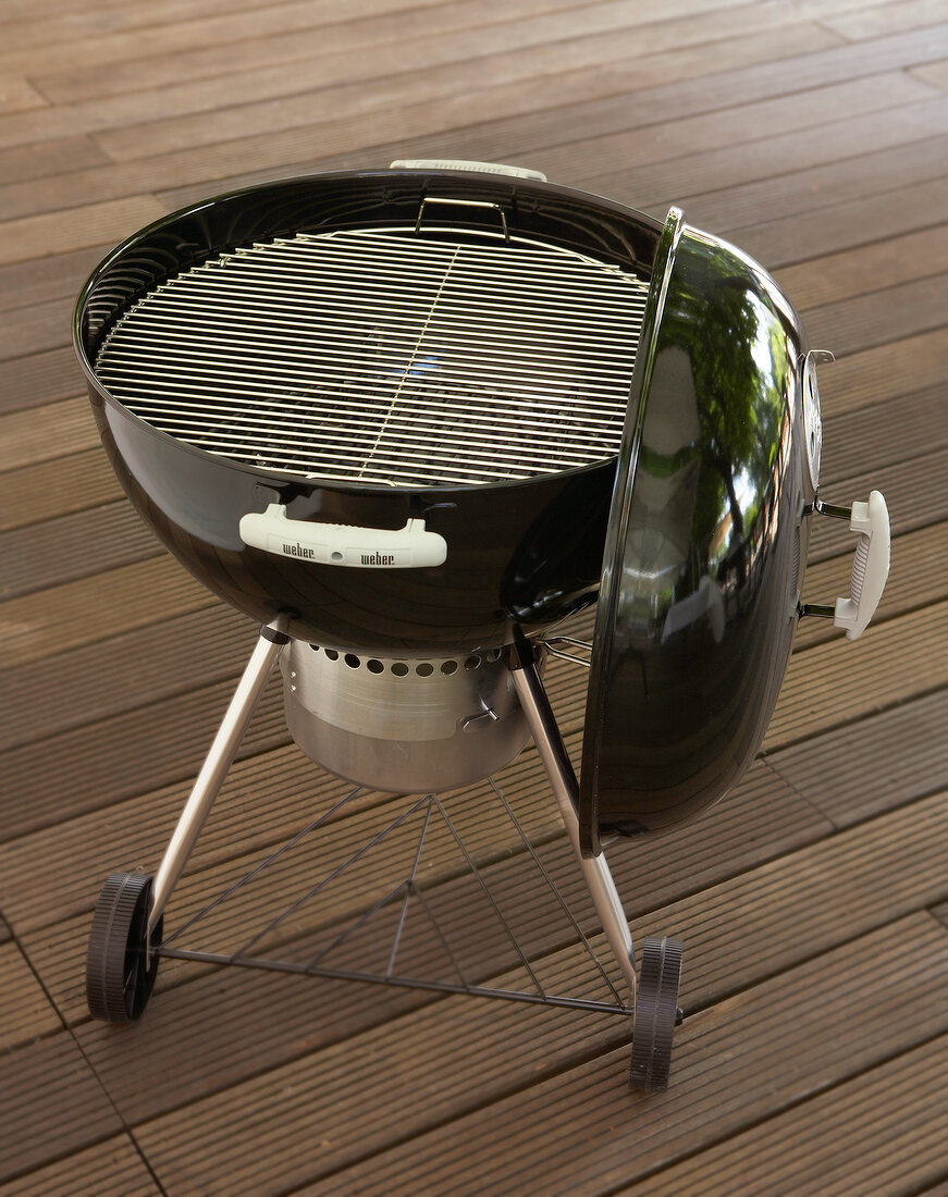 Round charcoal grill with wheels and lid