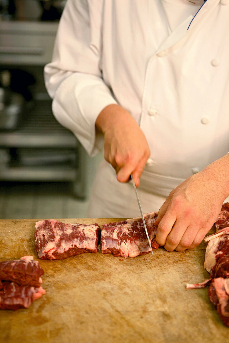 Chef cutting beef into pieces