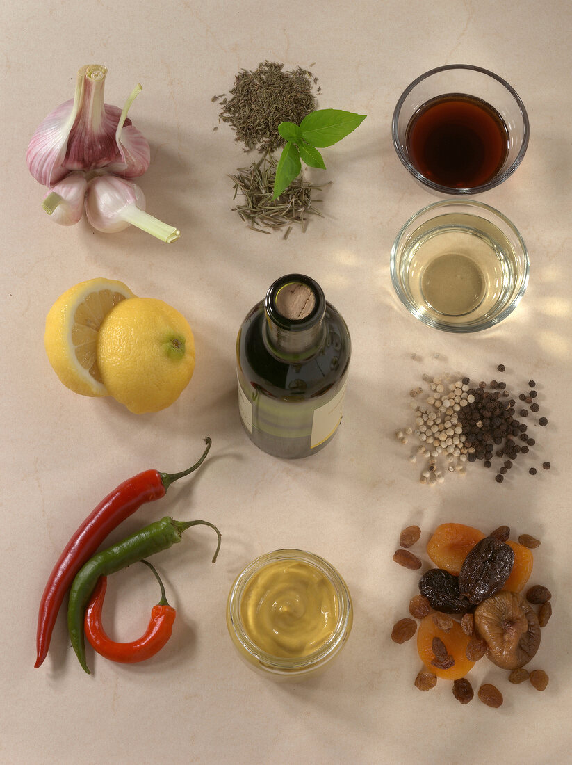 Garlic bulb, vinegar, herbs and other ingredients for sauces and dips on wooden board