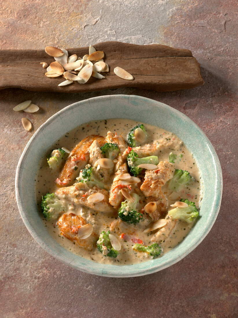 Skinless chicken breast with broccoli and almond sauce in bowl