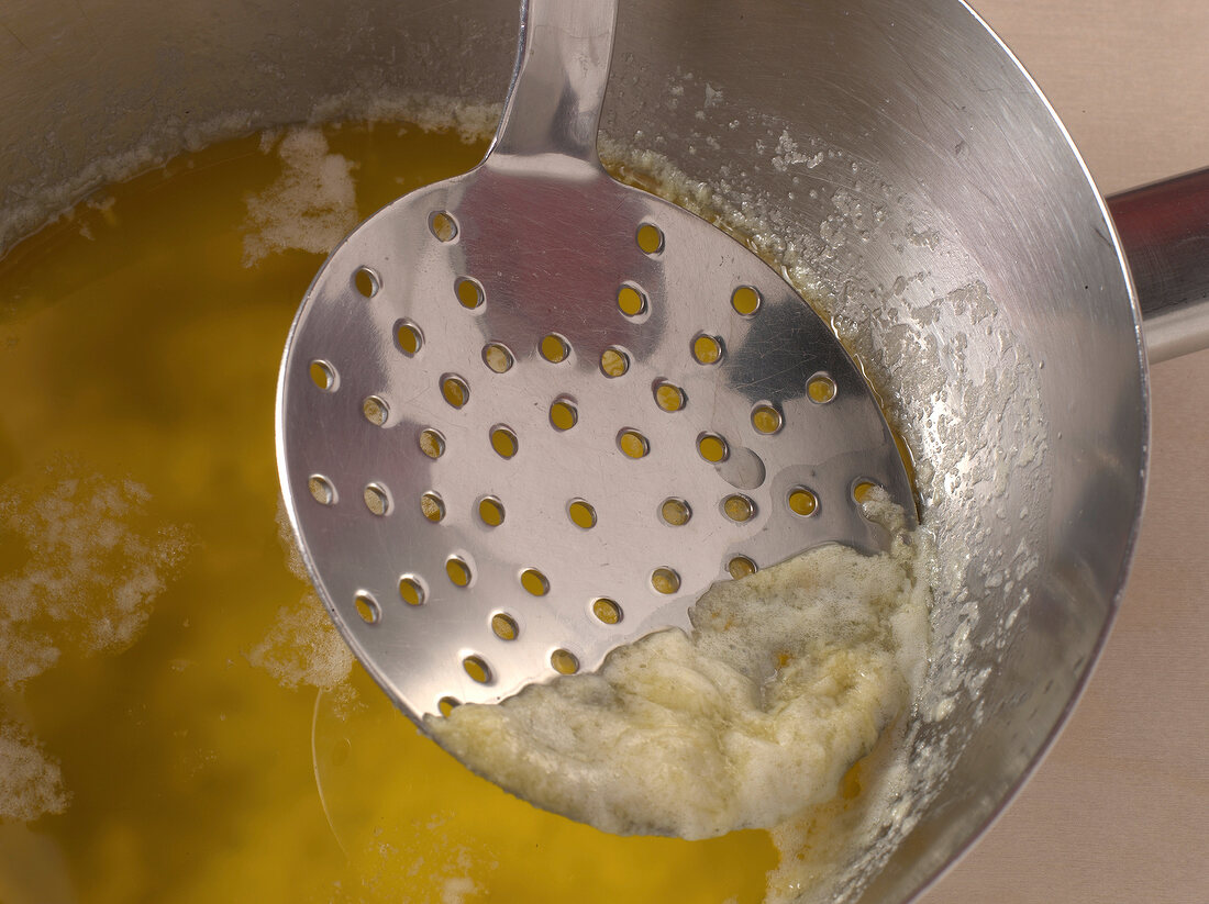 Butter foam being skimmed for preparation of hollandaise sauce, step 1