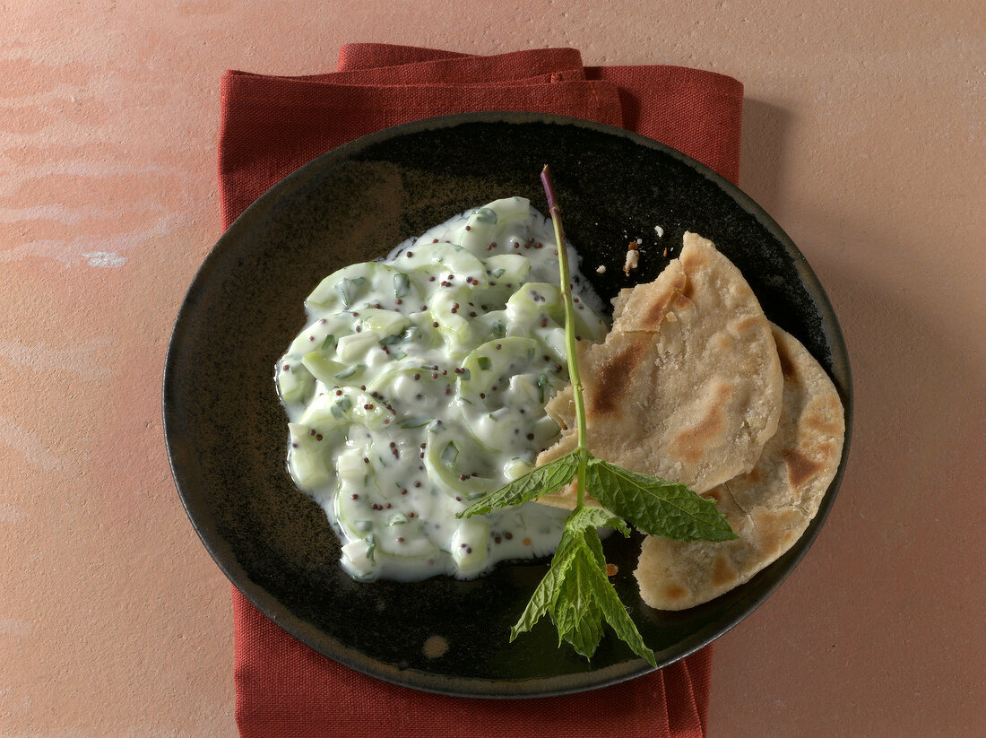 Chapati with mint, cucumber and onion raita on plate