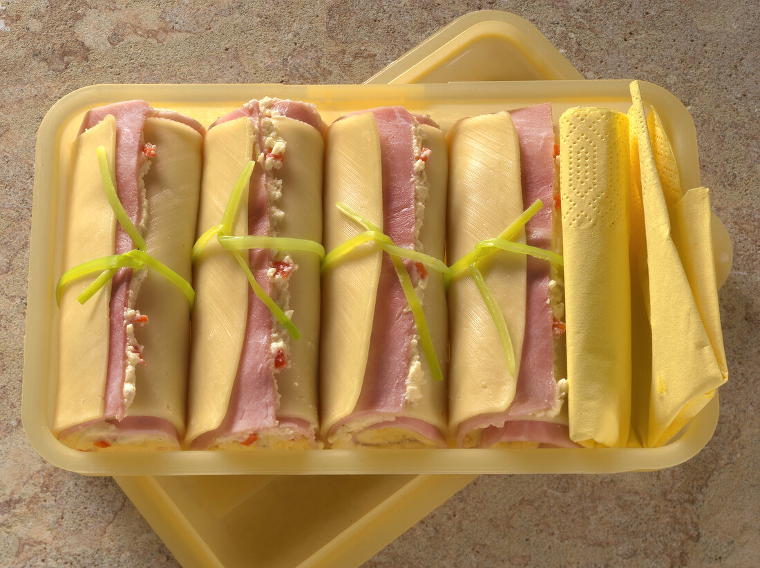 Four edam ham rolls with cream cheese remoulade in plastic box