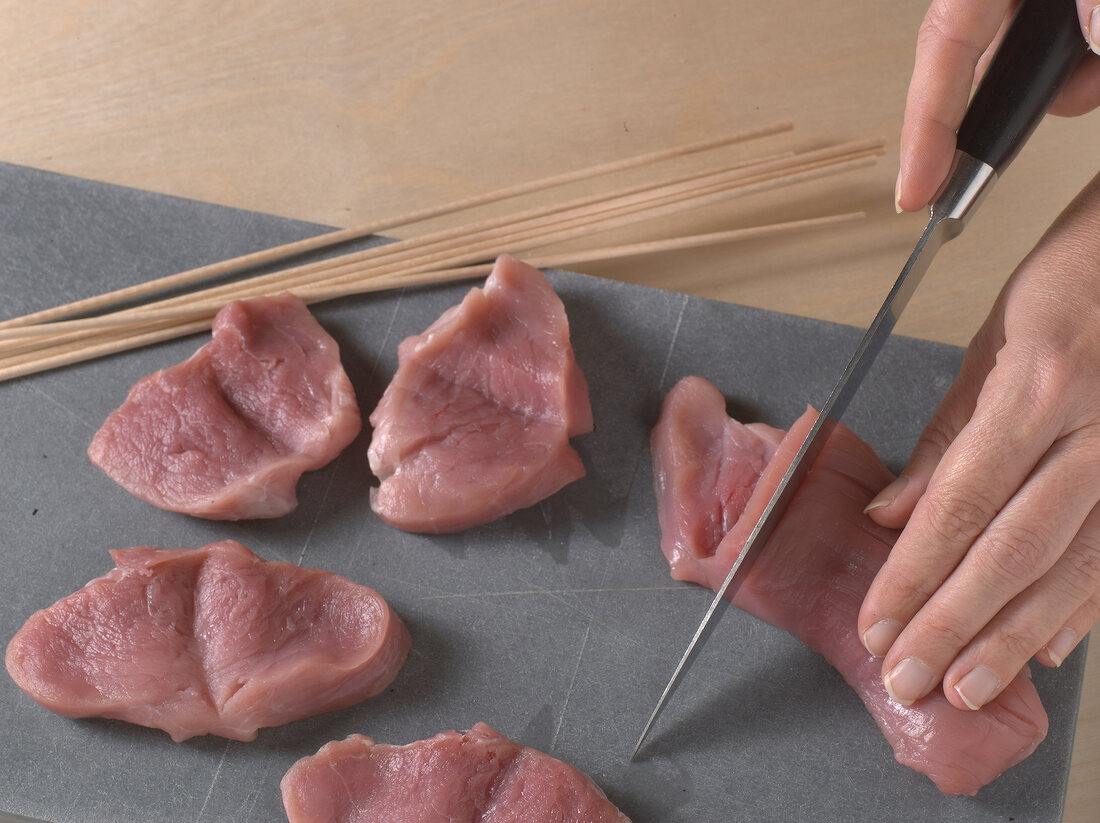 Loin being cut into pieces for preparation of schnitzel, step 1