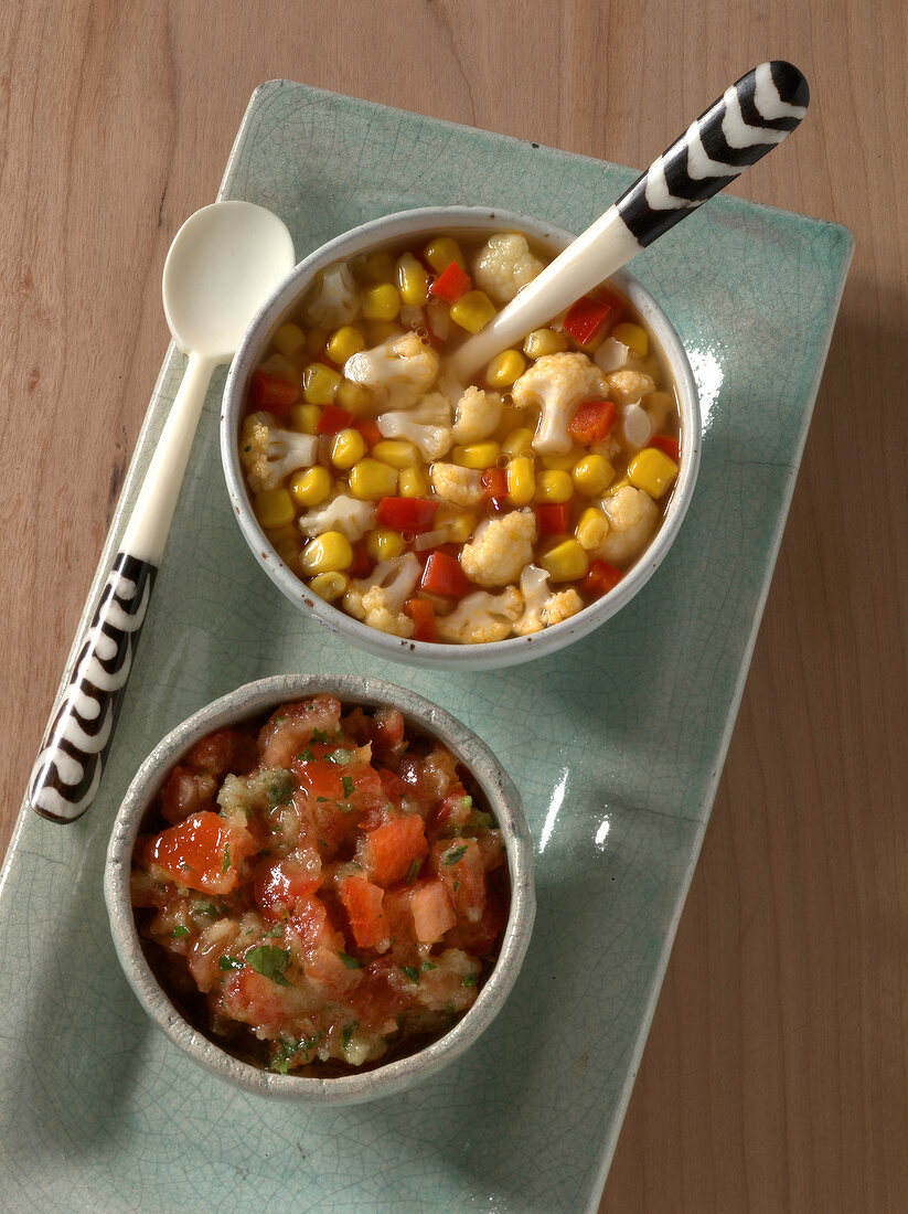 Raw tomato salsa and corn relish with cauliflower and peppers in bowls
