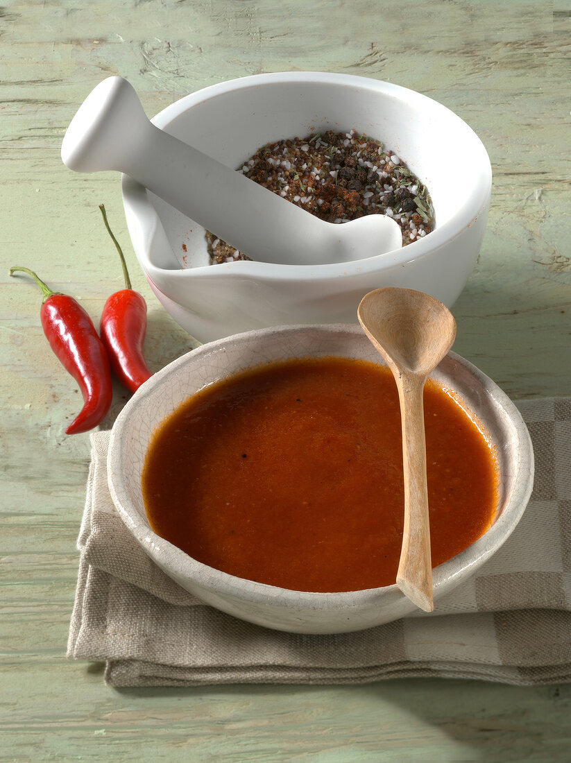 Bowl of hot chilli sauce and spices for barbecue in mortar and pestle 
