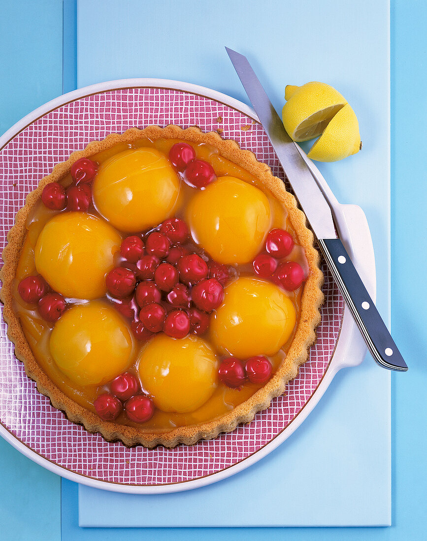 Backen, Obsttorte mit Kirschen und Pfirsichen auf einem Teller