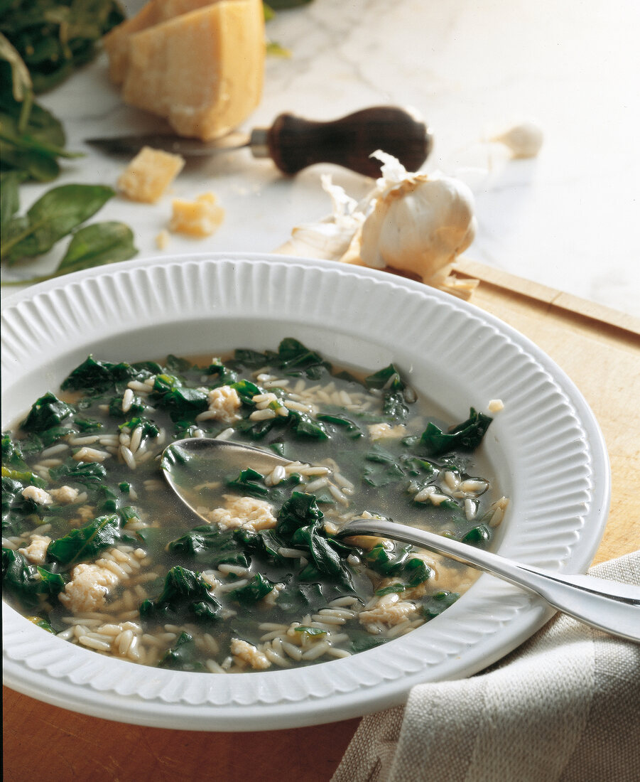 Spinach soup with rice, garlic and parmesan cheese on plate