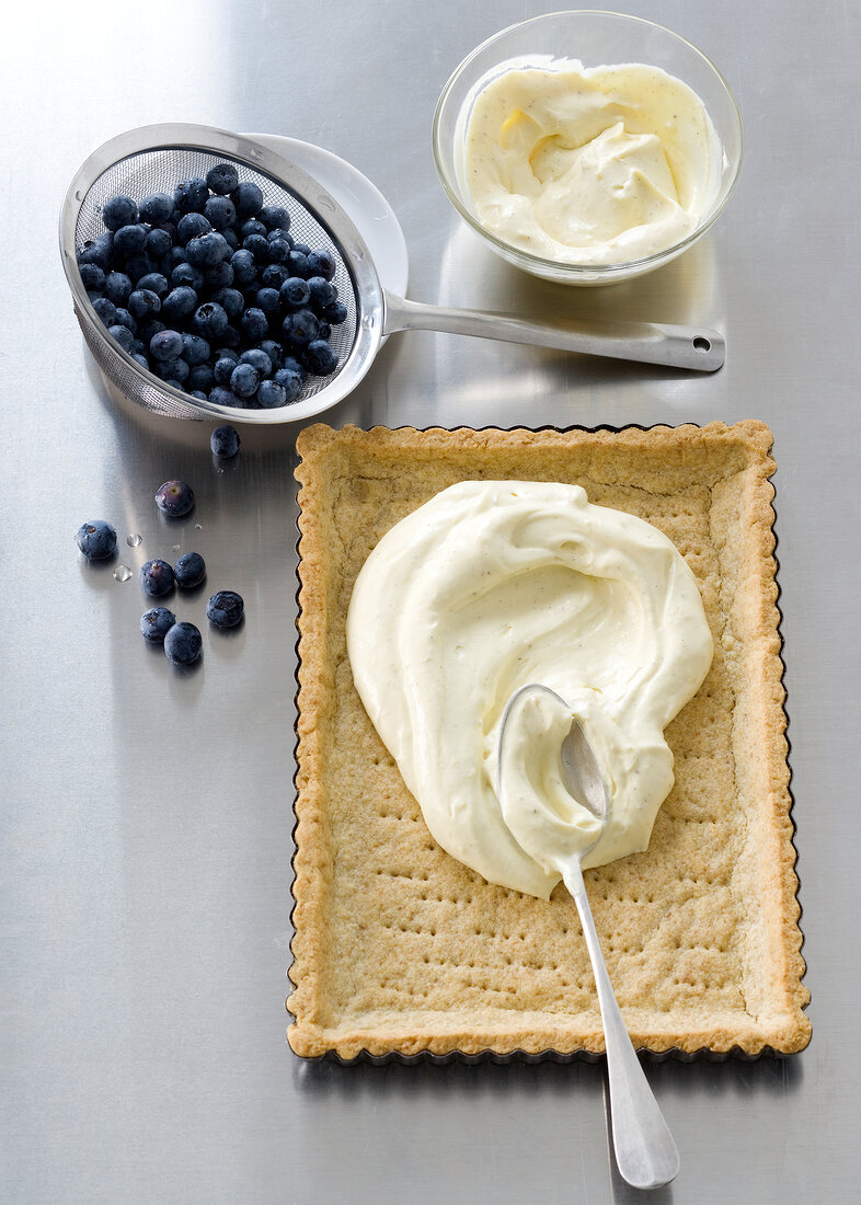 Blueberries, tart crust and other ingredients used for making blueberry tart