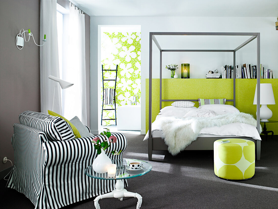 Bedroom with four poster bed and striped armchair with cushion