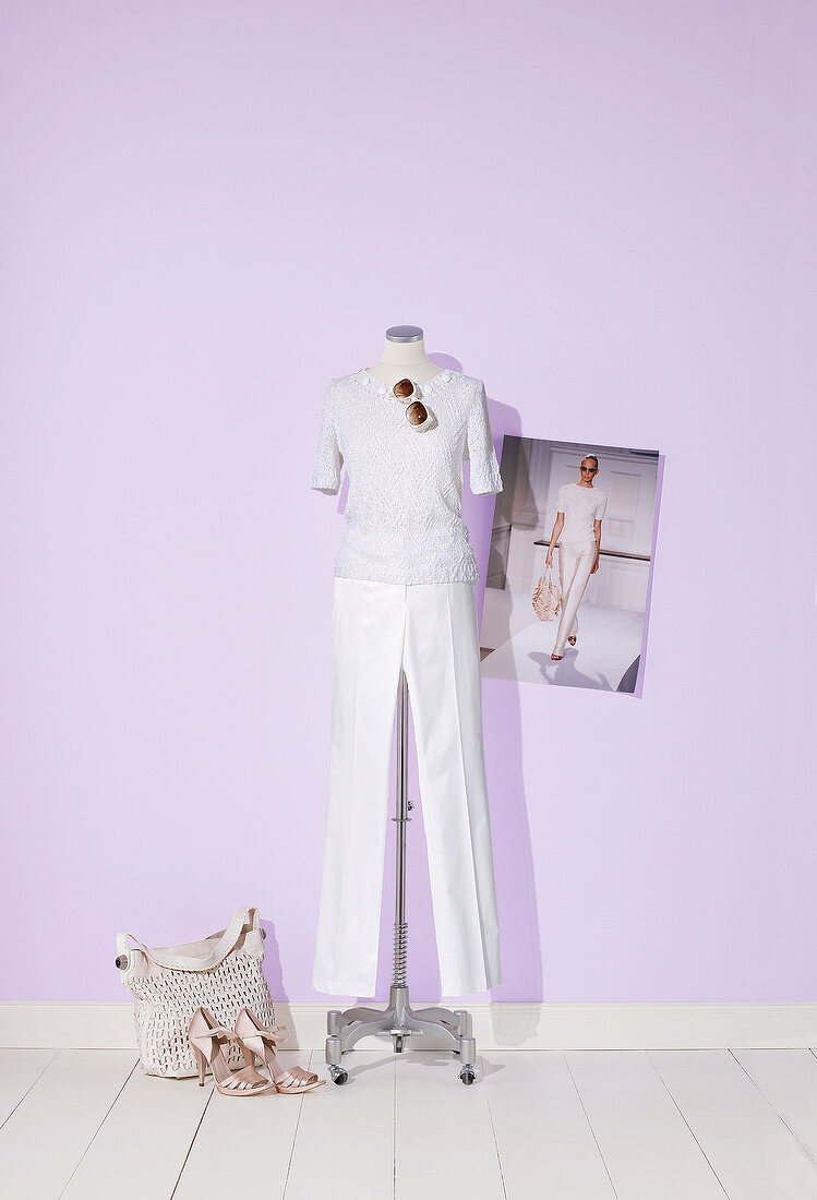 Short sleeved sweater and trousers on mannequin with bag and high heels on side