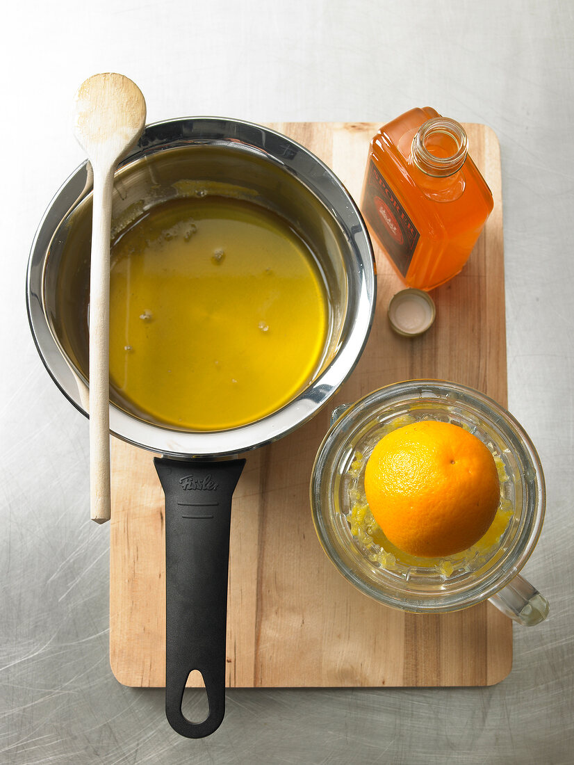 Orange syrup in sauce pan with wooden spoon over it