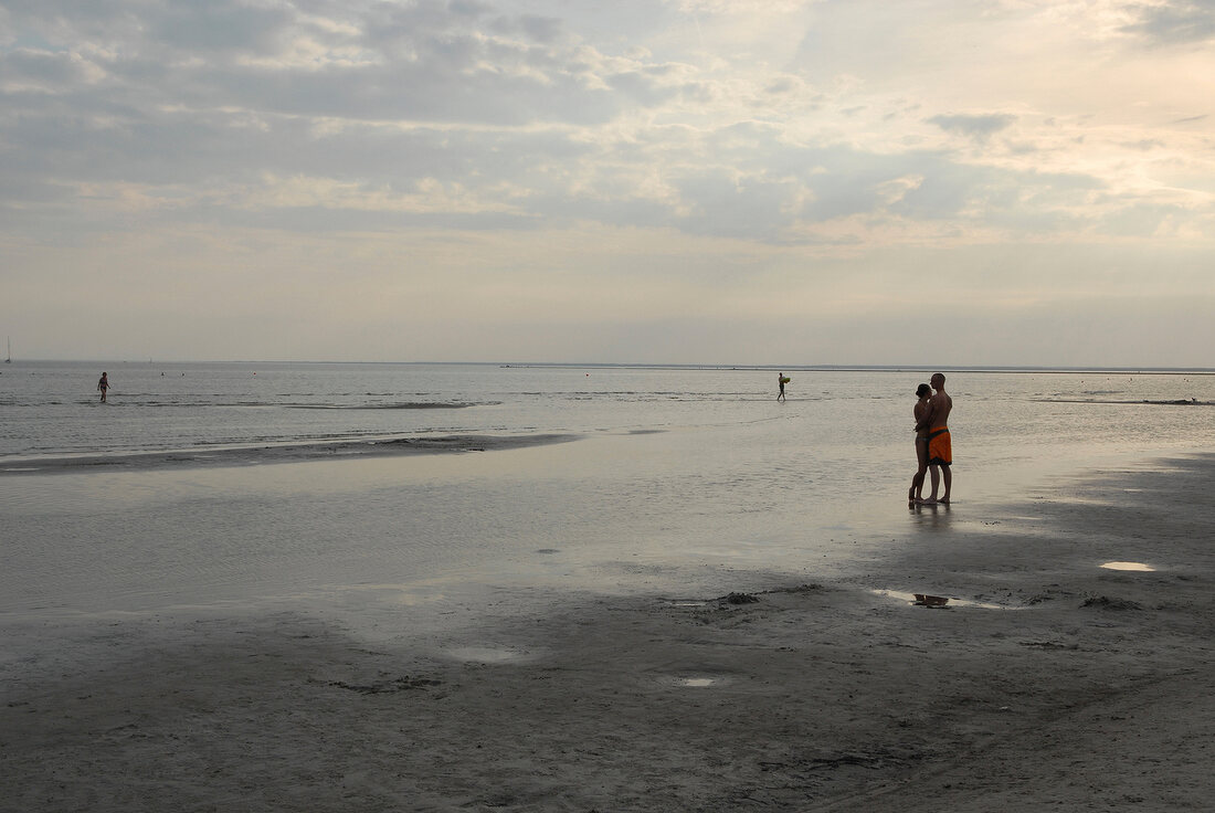 Couple embracing on beach in evening