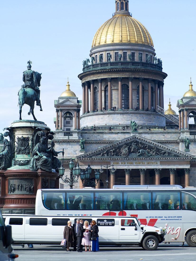 Facade of Isaac's Cathedral with golden dome and busy street in St. Petersburg, Russia