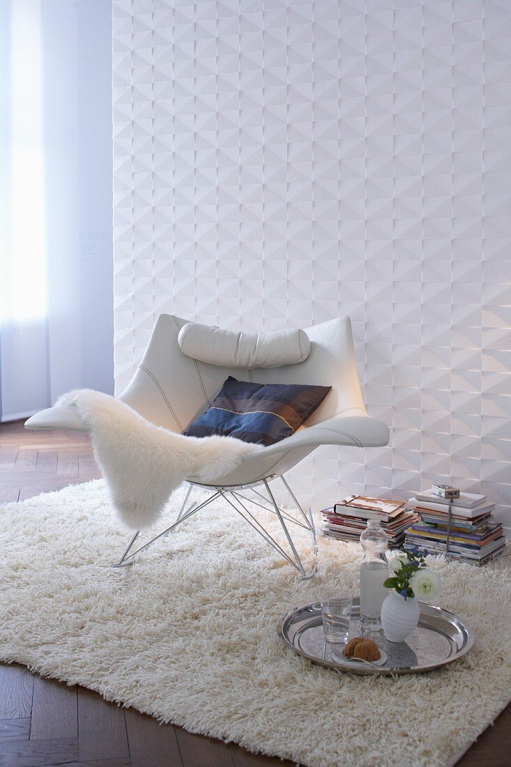 Sitzecke in Weiß mit Hochflorteppich & modernem Schaukelstuhl aus Metall & Lederauflage