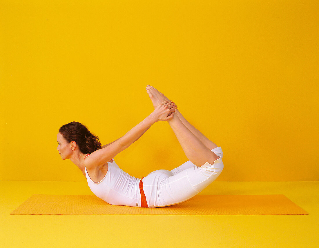 Pilates - Rocking: Bauchlage, Beine hochziehen, Oberkörper heben